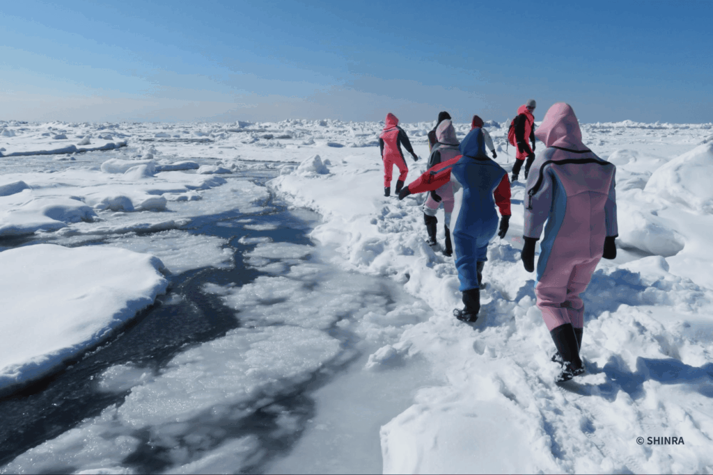 知床の流氷とその上を歩く人々