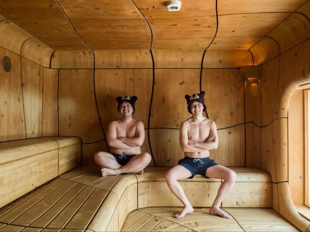 北こぶしリゾート内のサウナで代表取締役社長である桑島大介さんと専務取締役である桑島敏彦さんが座っている