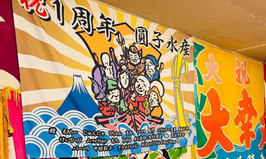 圓子水産店内に飾られている「圓子水産1周年記念」の旗