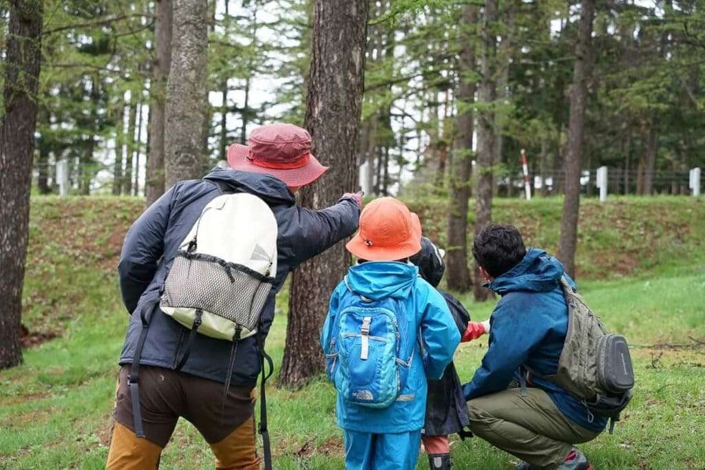 自然を案内するガイドとそれを楽しむ家族