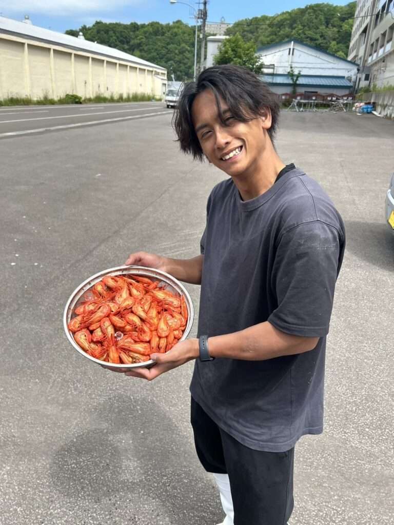 エビを持ちながら笑う圓子瑞樹さん